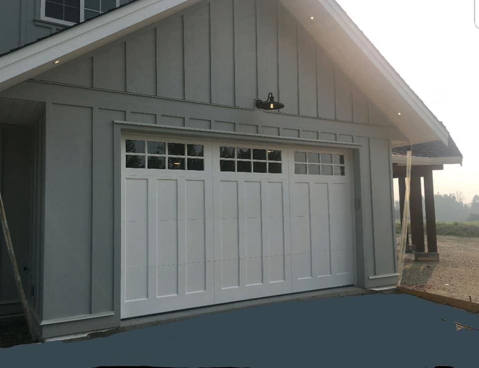 White barn-style garage door with an overlay