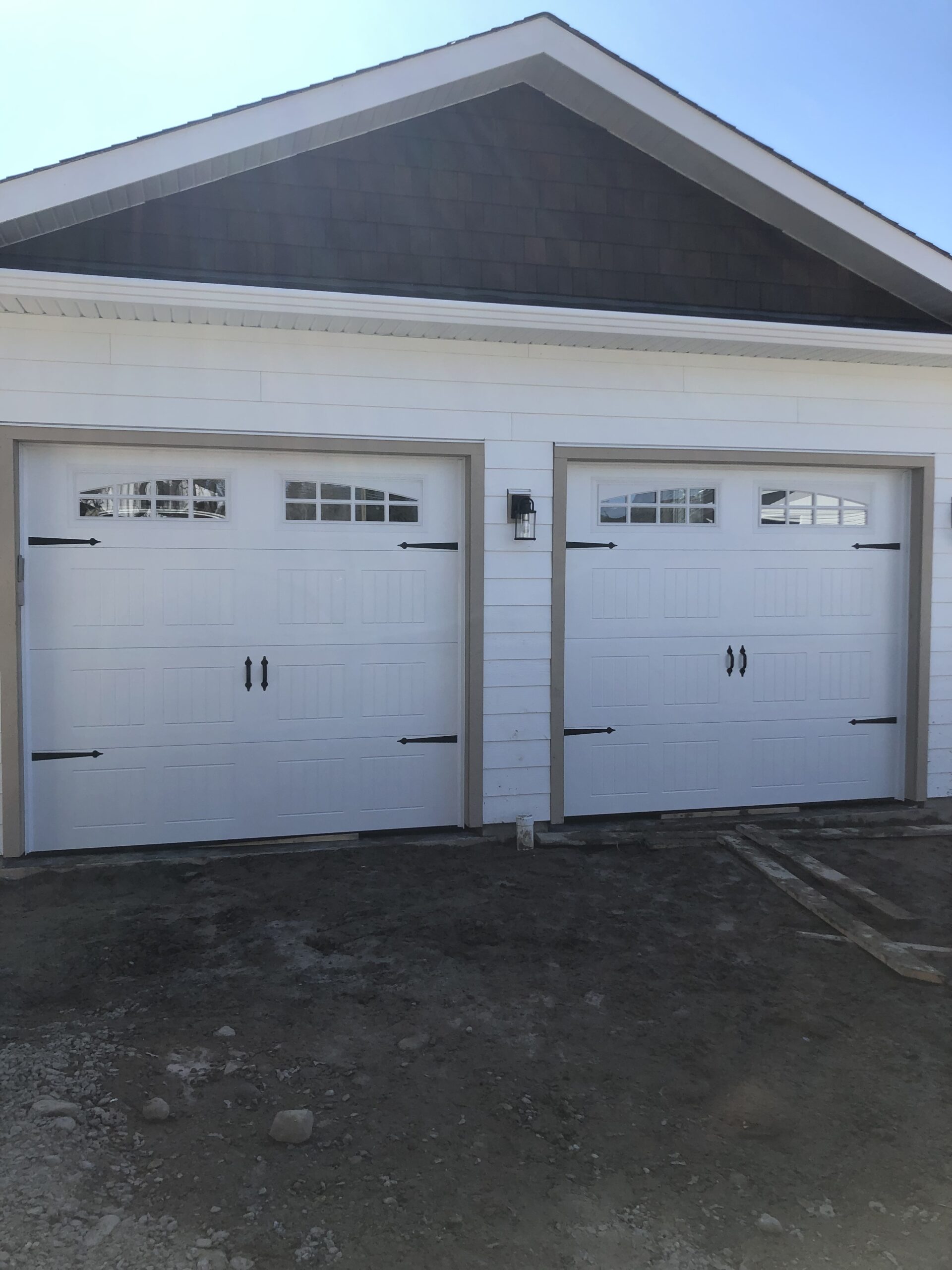 White carriage garage door with black handles and hinges