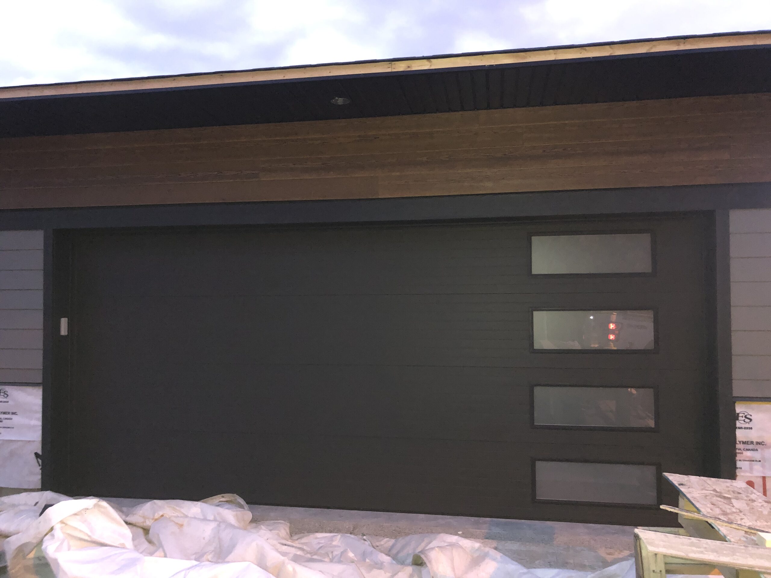 Modern dark garage door with windows on the side 