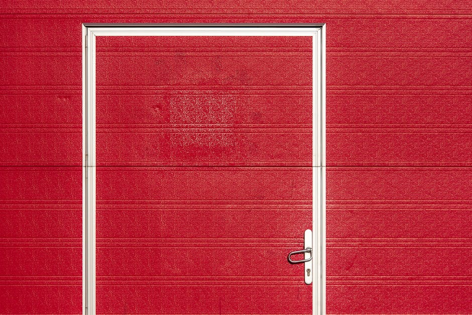 Red garage door with white trim, showcasing a modern design, relevant to budget-friendly garage door installation tips in Kelowna.