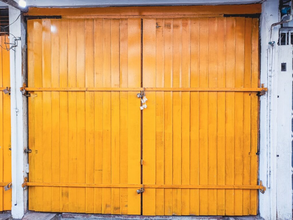 Garage door with a vibrant orange wooden design, showcasing maintenance aspects relevant to DIY garage door care and upkeep.
